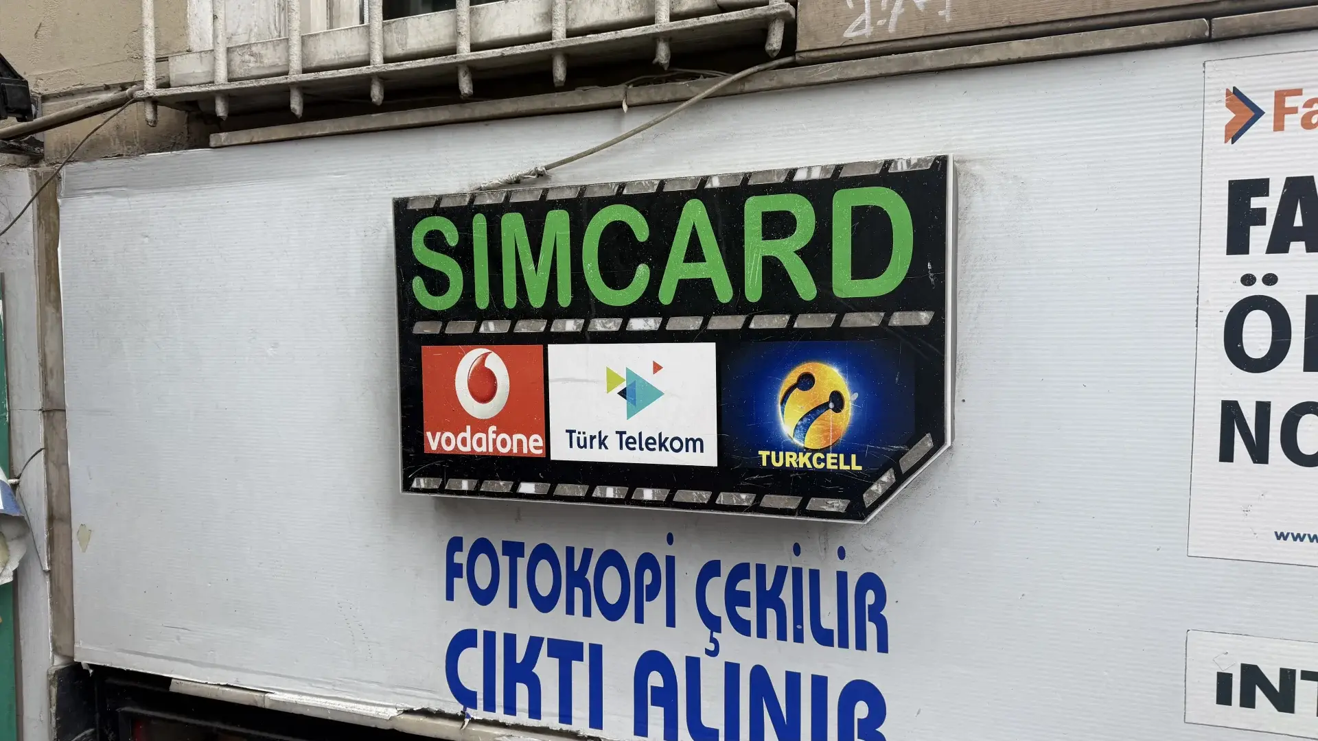 Bord van een simkaartwinkel in Istanbul met de logo's van de drie Turkse mobiele netwerken: Vodafone, Türk Telekom en Turkcell